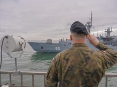 NATO kicks off huge BALTOPS drill to deter Russia Sailor in camouflage uniform saluting as a gray warship with the number 05 passes by on the water.