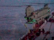 Video shows British forces board Russian shadow tanker Blurred night photo of a seafront pier with a concrete extension over water and green lights along its edge.