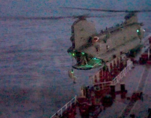 Video shows British forces board Russian shadow tanker Blurred night photo of a seafront pier with a concrete extension over water and green lights along its edge.