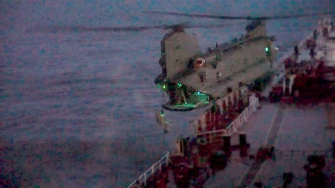 Video shows British forces board Russian shadow tanker Blurred night photo of a seafront pier with a concrete extension over water and green lights along its edge.