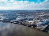 Balaena buys Cammell Laird owner in UK shipyard shake-up Aerial view of a harbor with two large white Stena Line ferries docked at the quay and industrial buildings nearby under a blue, cloudy sky.