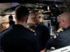 Starmer tells NATO chief UK will publish DIP before summit An older man with glasses speaks to a group of uniformed sailors inside a technical control room or ship compartment.