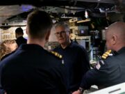 Starmer tells NATO chief UK will publish DIP before summit An older man with glasses speaks to a group of uniformed sailors inside a technical control room or ship compartment.