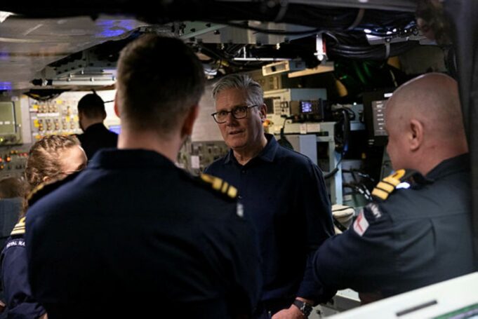 Starmer tells NATO chief UK will publish DIP before summit An older man with glasses speaks to a group of uniformed sailors inside a technical control room or ship compartment.