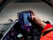 Red Arrows get Inzpire GECO system for 2026 season Pilot in a red flight suit uses a rugged tablet-style display in the fighter jet cockpit, surrounded by instrument gauges.