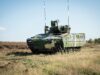 Rheinmetall lands huge Romania deal for Lynx, Skyranger Armored military tank on a grassy field under a clear blue sky, facing left.