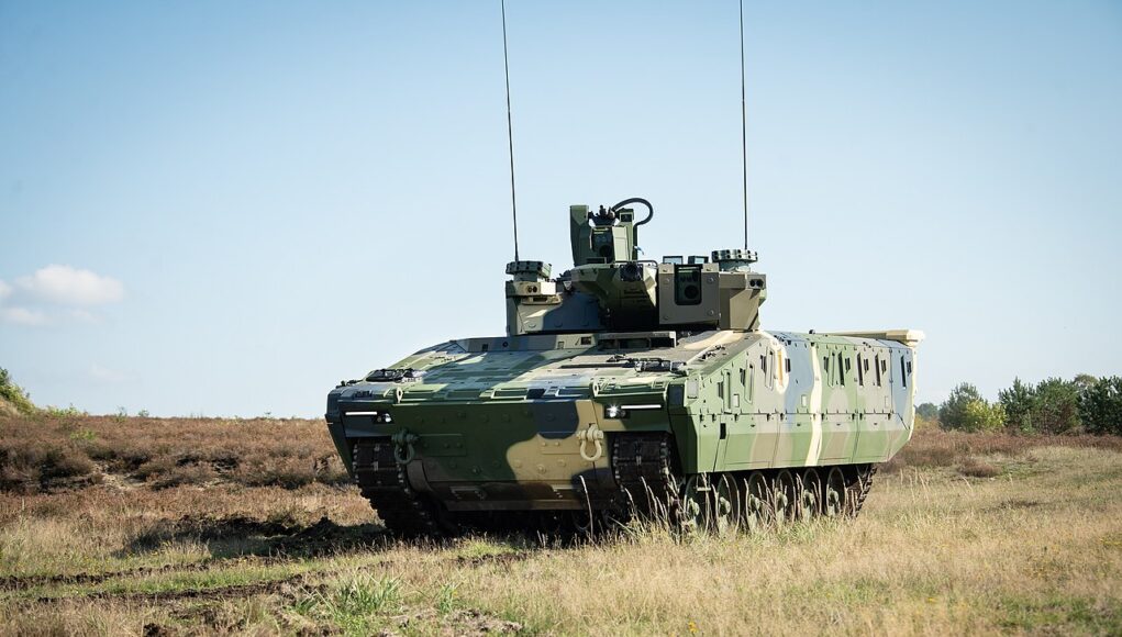 Hungarian_Lynx_KF-41 Armored military tank on a grassy field under a clear blue sky, facing left.