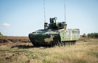 Rheinmetall lands huge Romania deal for Lynx, Skyranger Armored military tank on a grassy field under a clear blue sky, facing left.