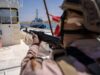 Briton guilty of brokering jets and missiles to war zones Soldier in camouflage aiming a rifle from the deck of a ship, with a small patrol boat visible in the water in the background.