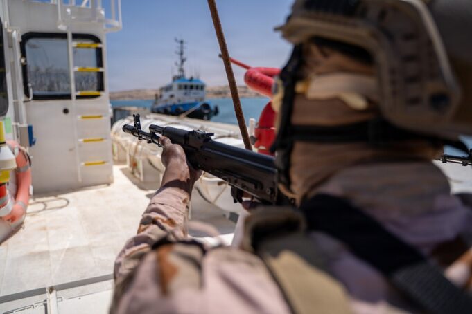 Briton guilty of brokering jets and missiles to war zones Soldier in camouflage aiming a rifle from the deck of a ship, with a small patrol boat visible in the water in the background.