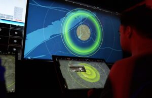 MARSS opens Nice base and doubles AI team for drone fight People in a dark control room monitor a large radar/map display with bright green concentric rings on a wall-sized screen