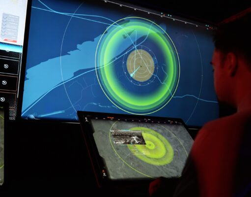 MARSS opens Nice base and doubles AI team for drone fight People in a dark control room monitor a large radar/map display with bright green concentric rings on a wall-sized screen