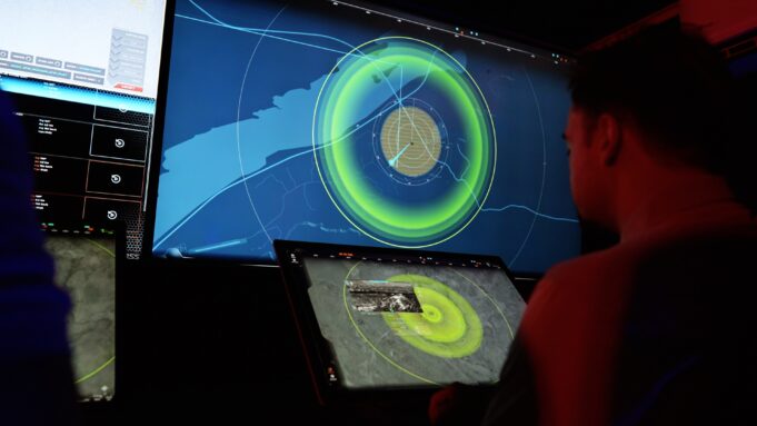 MARSS opens Nice base and doubles AI team for drone fight People in a dark control room monitor a large radar/map display with bright green concentric rings on a wall-sized screen