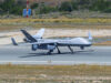 British drone spotted carrying covert spy pod Unmanned RAF surveillance aircraft on a runway, with two large wings and a light gray fuselage marked 'ROYAL AIR FORCE'.