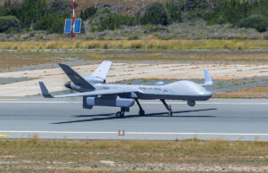Unmanned RAF surveillance aircraft on a runway, with two large wings and a light gray fuselage marked 'ROYAL AIR FORCE'.
