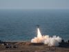 Britain shows off home-grown deep-strike weapon Small airplane launches a rocket from a coastal test site, flame and smoke plume rising toward the sky over the ocean.