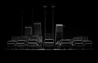 CSG unveils Trident layered air defence at Eurosatory Row of large trucks with tall antenna masts silhouetted against a dark background, forming a straight line.