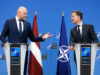 Rutte hails Latvia ahead of Ankara summit as drone downed Two suited men stand at podiums with NATO logos, speaking to each other during a press conference, with a Latvia flag and a NATO flag behind them.