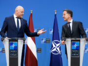 Rutte hails Latvia ahead of Ankara summit as drone downed Two suited men stand at podiums with NATO logos, speaking to each other during a press conference, with a Latvia flag and a NATO flag behind them.