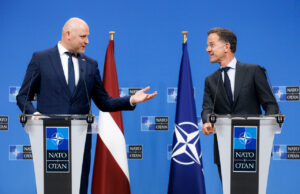 Rutte hails Latvia ahead of Ankara summit as drone downed Two suited men stand at podiums with NATO logos, speaking to each other during a press conference, with a Latvia flag and a NATO flag behind them.
