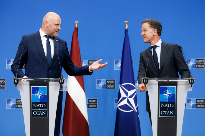 Rutte hails Latvia ahead of Ankara summit as drone downed Two suited men stand at podiums with NATO logos, speaking to each other during a press conference, with a Latvia flag and a NATO flag behind them.