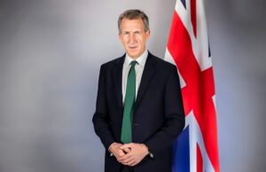 Who is Dan Jarvis? A look at Britain’s new defence secretary Portrait of a man in a dark suit and green tie standing beside a Union Jack flag behind him. (informative)
