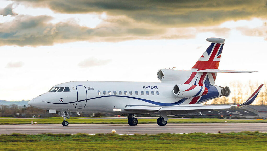 envoy White business jet with Union Jack tail taxiing on a runway under a cloudy sky