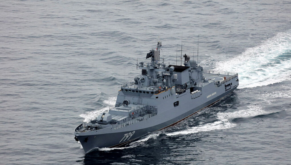 grigorivich Overhead view of a gray military destroyer cutting through the ocean with the hull number 799 visible on the bow; wake behind the ship.