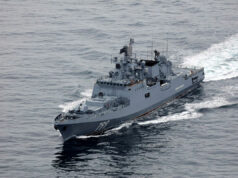 Russian warship fired warning shots at British vessel near UK Overhead view of a gray military destroyer cutting through the ocean with the hull number 799 visible on the bow; wake behind the ship.