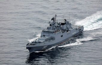 Russian warship fired warning shots at British vessel near UK Overhead view of a gray military destroyer cutting through the ocean with the hull number 799 visible on the bow; wake behind the ship.