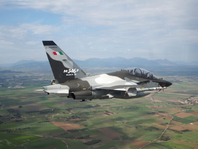 Indonesia signs for 12 M-346 F light fighters from Leonardo Military jet in flight, Italian M-346F trainer with flag on tail against a rural valley and mountains far below.