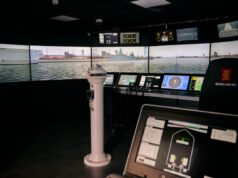 VR bridge simulator boosts Royal Navy training capacity Interior of a ship bridge simulator showing panoramic harbor screens and multiple navigation consoles.