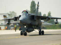 UK has 42 Jaguar jets two decades after retirement Military jet aircraft taxiing on a runway with ground crew in high-visibility vests in the background at an airbase.