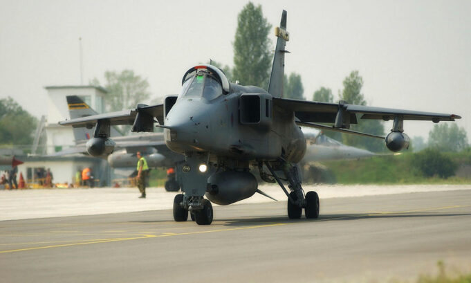 UK has 42 Jaguar jets two decades after retirement Military jet aircraft taxiing on a runway with ground crew in high-visibility vests in the background at an airbase.