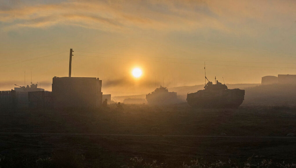 45165204.jpg.iCee9uqCMjGpa0djYBMA.RGn42CemcN Sunrise over a foggy field with silhouettes of tanks and a small building in the distance.