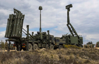 Sky Sabre doubling on track with deliveries from late 2026 Military mobile missile system on a truck with multiple vertical launch tubes, in a dry open area under a cloudy sky.
