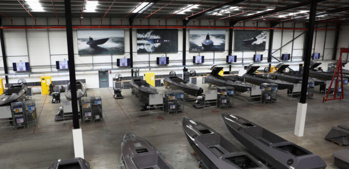 Kraken hits £1bn valuation after funding round Industrial boat factory with row of speedboats on workbenches and tools along the wall