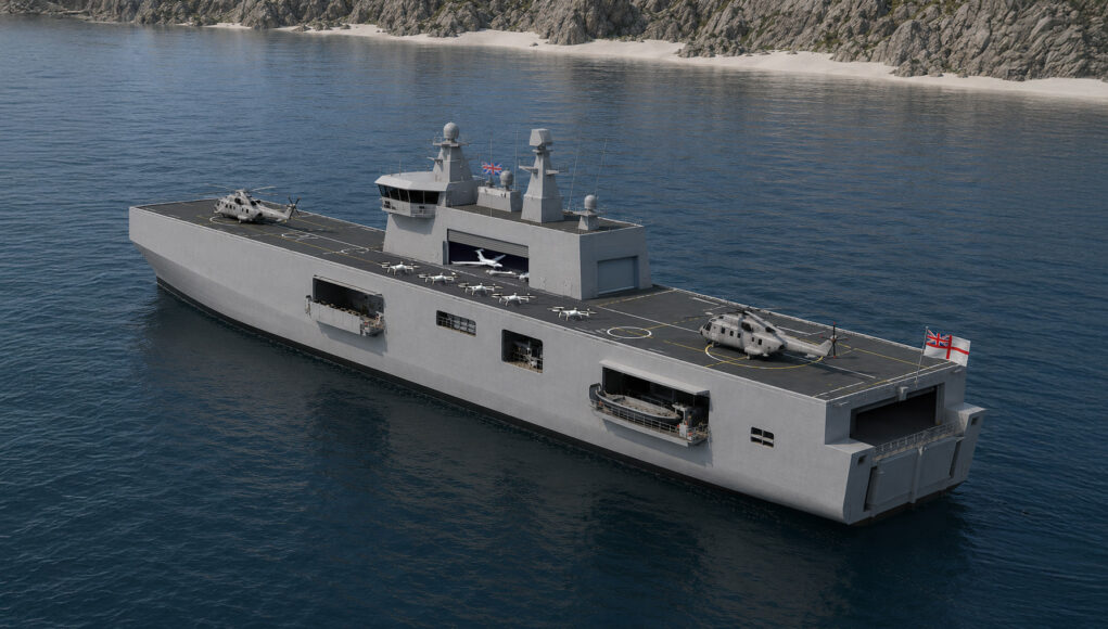 ATS Large gray aircraft carrier on calm blue water with several helicopters on the flight deck and rocky coastline in the background, flags at the stern.