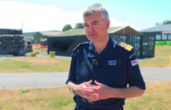 From Thursday War to rewind button – how FOST is changing Man in a dark blue uniform stands outdoors, hands clasped, with a facility and equipment behind him.