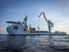 Britain’s seabed warfare vessel to get upgrades Large white offshore support vessel with a tall crane on calm blue sea, hull marked K60.