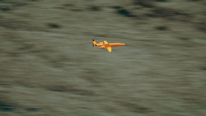 UK awards Europe’s first low-cost drone interceptor deals Small orange propeller airplane in flight over a blurred grassy landscape, viewed from the side.