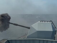 British frigate opens fire off UK coast Military vessel at sea fires its main gun, ejecting a dense black smoke plume from the muzzle.