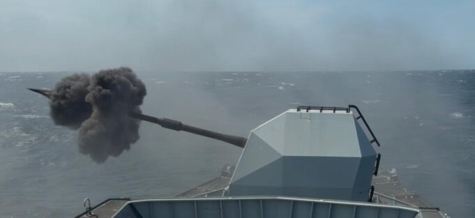 British frigate opens fire off UK coast Military vessel at sea fires its main gun, ejecting a dense black smoke plume from the muzzle.
