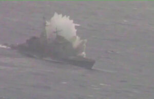 Canadian submarine sinks American warship in Pacific Ex Small boat on rough water with a large white spray behind it, suggesting a splash or plume from the vessel.