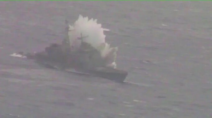 Small boat on rough water with a large white spray behind it, suggesting a splash or plume from the vessel.