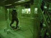 New Porton Down lab to counter biological threats Soldier in camouflage gear walking on a treadmill inside a sealed lab chamber, with a technician visible through a window in the background.