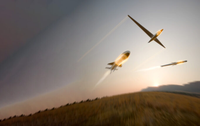 BAE unveils BlackThorn warhead for drones and missiles Three gliders soaring in a dusky sky with light-trail contrails behind them.
