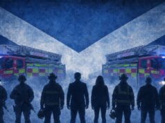 Silhouetted firefighters stand in front of two ladder fire engines with blue emergency lights, against a large Scottish flag backdrop.