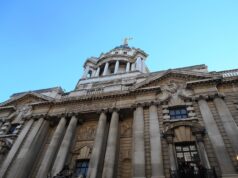 Man jailed after explosives guides found on phone Facade of a grand neoclassical building with tall columns and a domed tower against a blue sky.