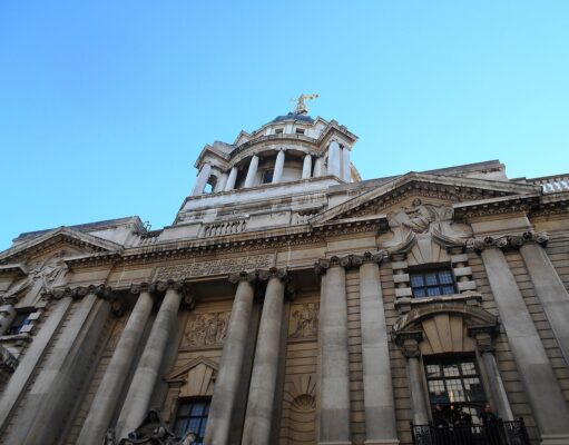 Man jailed after explosives guides found on phone Facade of a grand neoclassical building with tall columns and a domed tower against a blue sky.